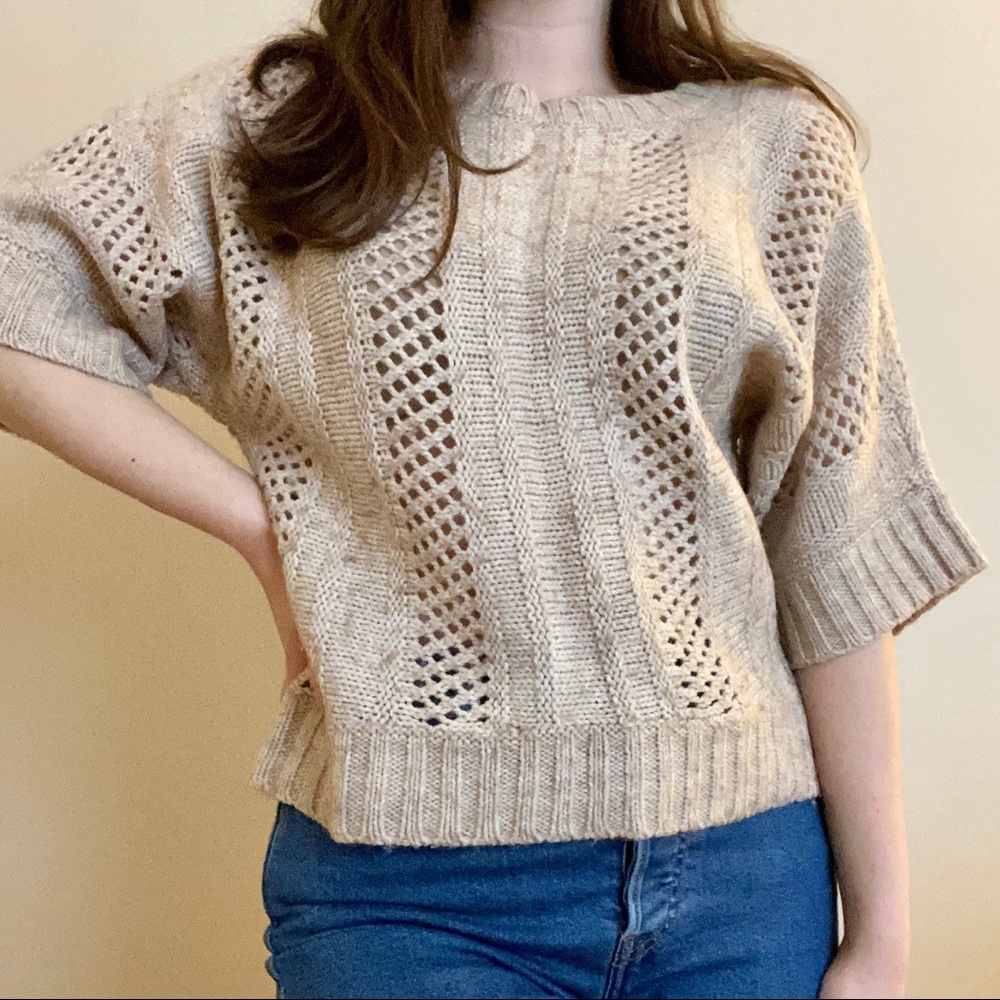 Short sleeved tan cable knit sweater.